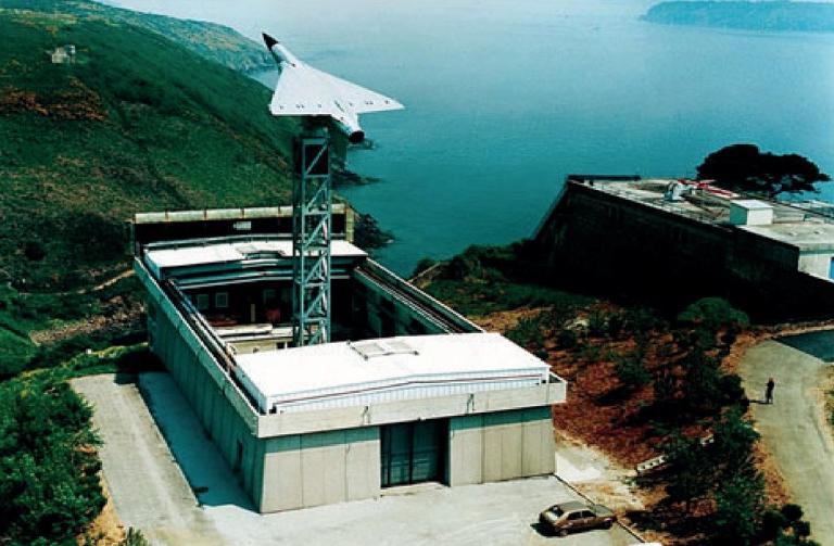 Vue aérienne oblique du bâtiment de la base d'essais de radiodétection du Mengant. Un pylône supportait une maquette d'avion à l'échelle réelle. Cette installation a été déconstruite