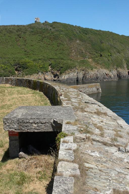 Vue de la batterie basse du Mengant : parapet et niche à munitions en béton armé (état en 2009). En arrière-plan sur la hauteur, la tour de mesures de Kerdalaez