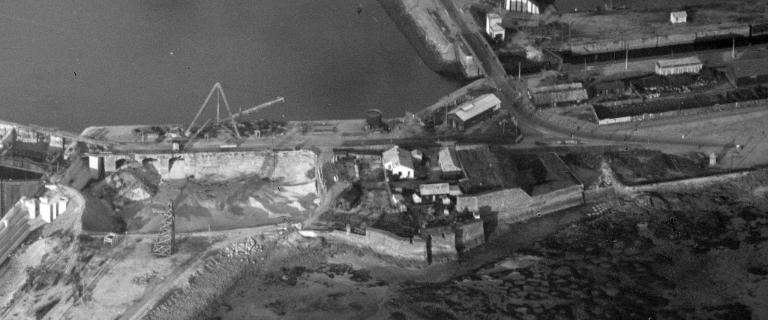 Vue aérienne oblique depuis l'ouest-sud-ouest montrant le chantier de construction de la grande écluse du Naye, 27 septembre 1929. Sur la photographie, on voit notamment l'avant-port de Saint-Servan en cours de remblaiement et le fort du Naye