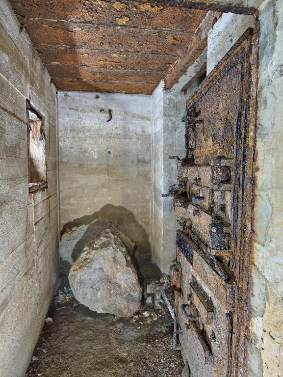 Vue de l'entrée est depuis le sas. A gauche, le créneau blindé protégeant l'entrée est (coffrage en bois en place). A droite, la porte blindée à deux vantaux