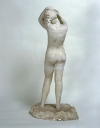 Statue : Femme debout en maillot, fixant une épingle à cheveux