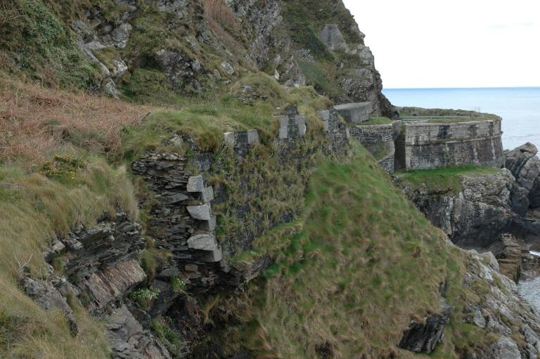 Vue de la partie ouest : vestiges du parapet percé d'embrasures (état en 2005). On distingue le chaînage et les joues des embrasures en pierre de taille de granite gris. En arrière-plan à droite, la batterie de Cornouaille