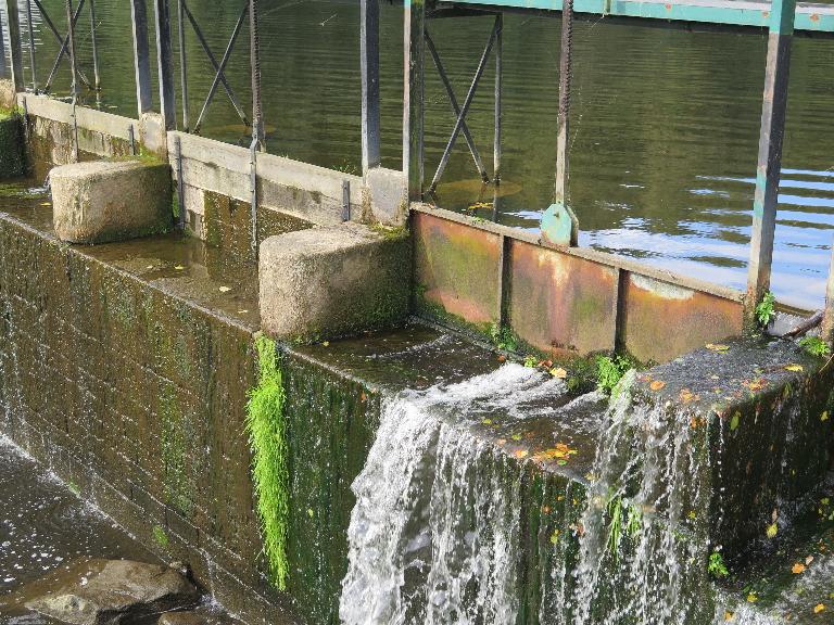 Vannettes en bois et métalliques, avec une pile rectangulaire au premier plan puis deux piles arrondies, déversoir de Moulin neuf 
