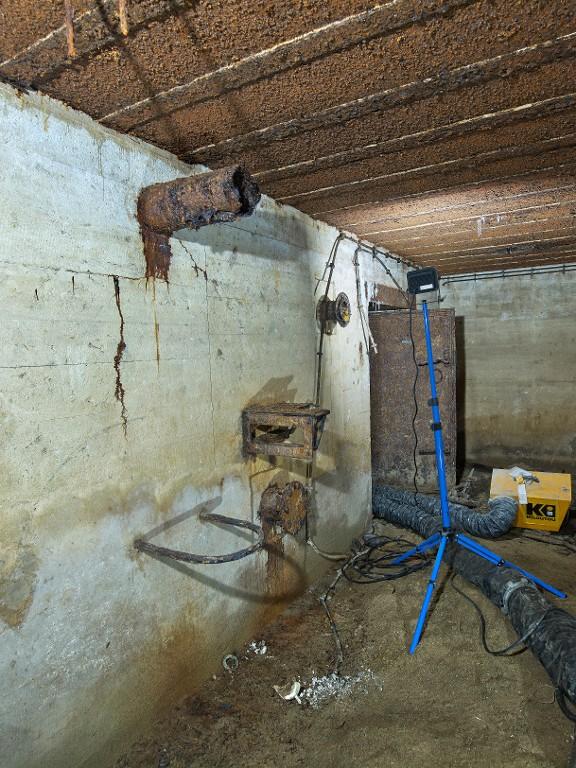 Vue de la salle de garde : emplacement du système de filtration. Au premier plan, l'arceau métallique servant à poser les filtres à charbon. Au fond, la porte étanche du magasin à munitions est