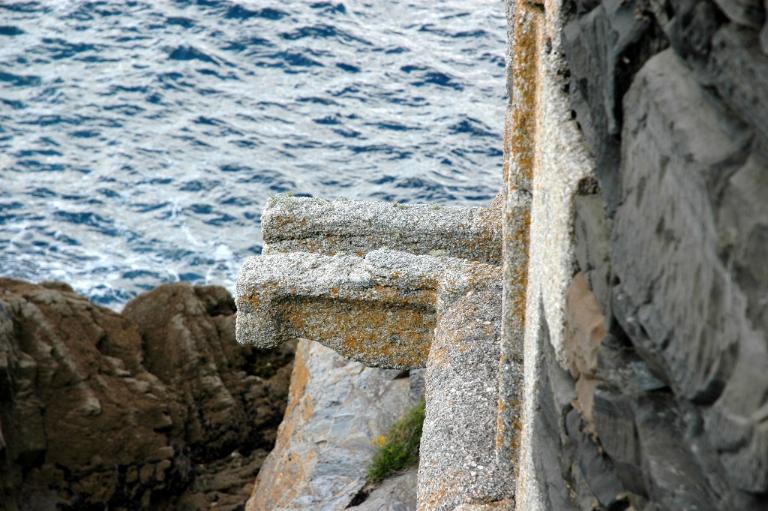 Vue de détail de l'escarpe et du parapet : gargouille (état en 2005). Marquant la jonction entre l'escarpe et le parapet, le cordon en granite